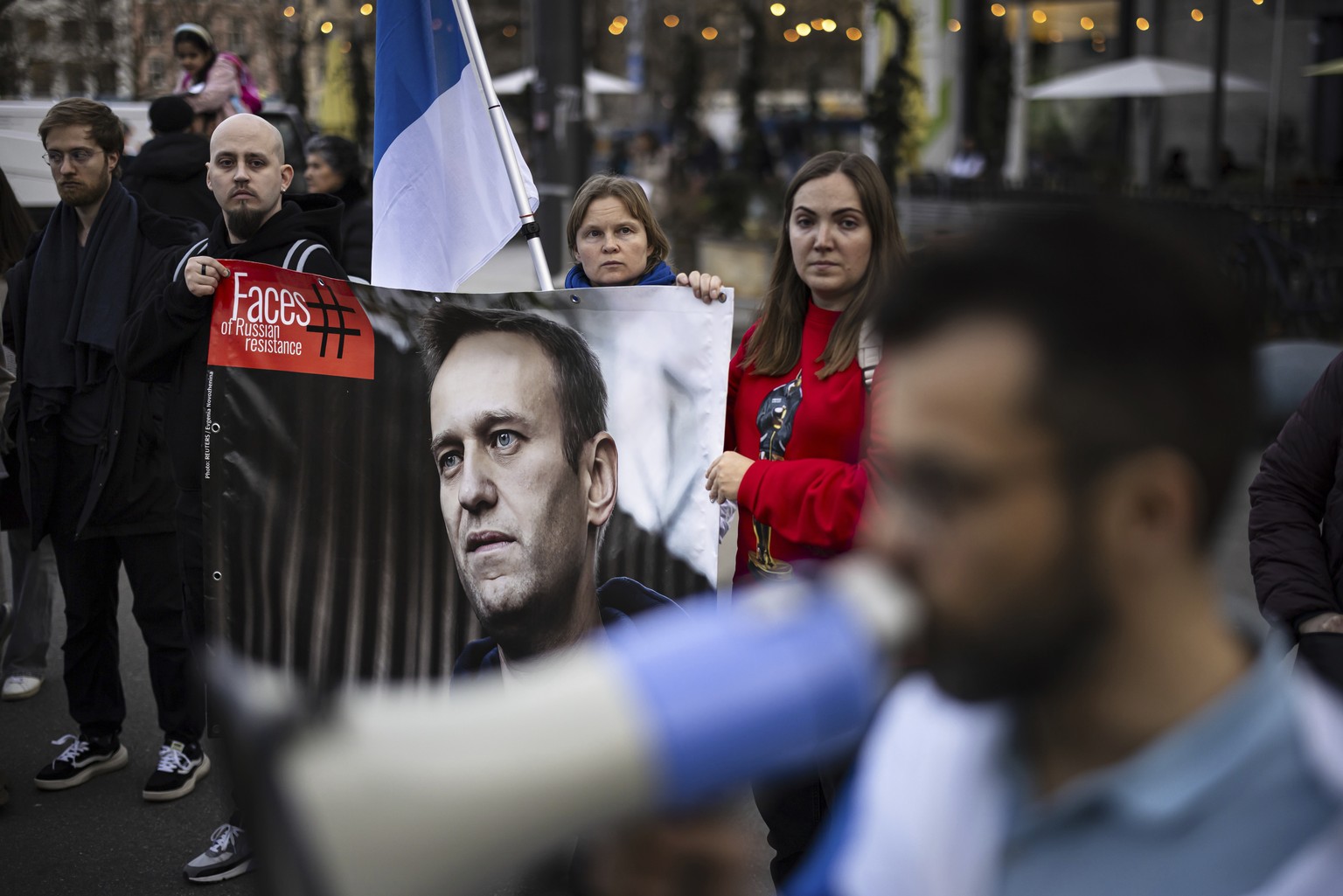 Protestors hold a placard with a picture of Alexei Navalny after the announcement of the death of the Russian opposition leader, on the place des Nations in front of the European headquarters of the U ...