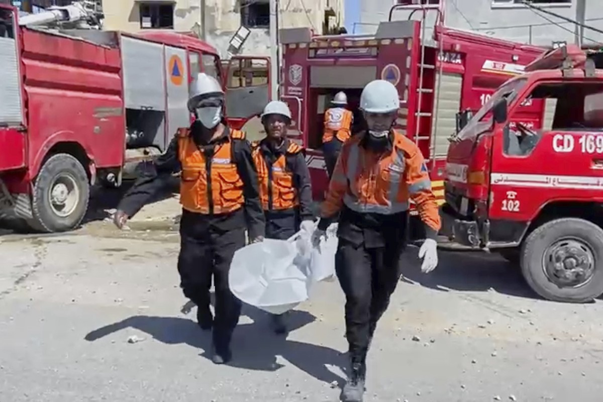 In this frame grab from a video released by Gaza Civil Defense, workers collect human remains after an Israeli strike on a home in Khan Younis killed nine of a doctor's ten children while she was ...