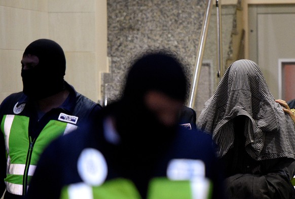 A man accused of belonging to Islamic State is led by Spanish National Police officers after being arrested in Gijon, Spain, October 11, 2016. REUTERS/Eloy Alonso