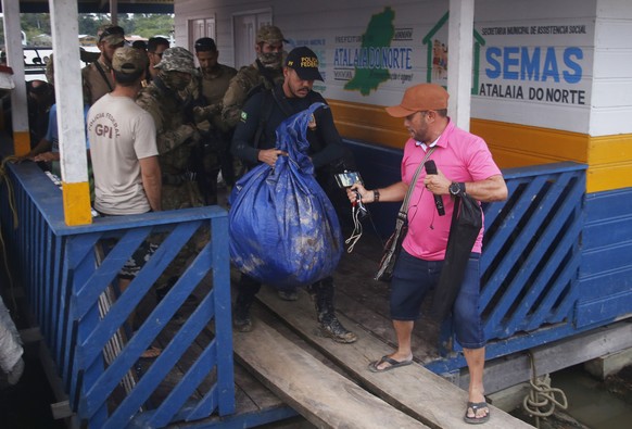 Federal police officers arrive at the pier with items found during a search for Indigenous expert Bruno Pereira and freelance British journalist Dom Phillips in Atalaia do Norte, Amazonas state, Brazi ...
