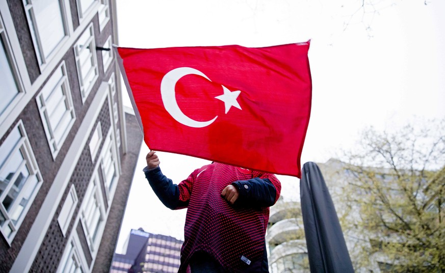 epa05911669 A boy waves with a Turkish flag in front of the Turkish consulate in Rotterdam, The Netherlands, 16 April 2017. State-run news agency Anadolu reports a narrow lead for the &#039;Yes&#039;  ...