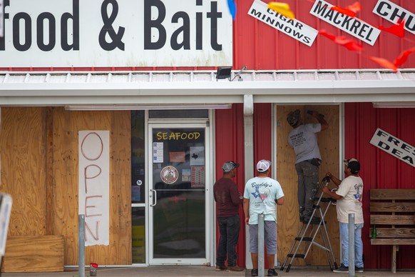 epa11466115 Workers board up the doorway of a business in advance of landfall by Tropical Storm Beryl in Matagorda, Texas, 07 July 2024. The storm is forecast to strengthen into a hurricane overnight  ...