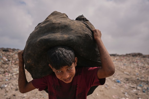 Omar Ghabin, 14, looks at the camera as he carries a bag of items he collected from the landfill in Deir al-Balah, central Gaza Strip, Thursday, July 23, 2026. (AP Photo/Abdel Kareem Hana)
APTOPIX Isr ...