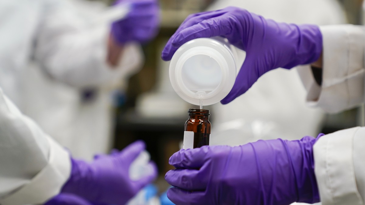 FILE - Eva Stebel, water researcher, pours a water sample into a smaller glass container for experimentation as part of drinking water and PFAS research at the U.S. Environmental Protection Agency Cen ...