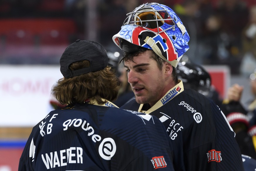 Gotterons Goalie Ludovic Waeber, links, und Gotterons Goalie Reto Berra, rechts, sprechen nach der Niederlage (0-3), beim Eishockey Meisterschaftsspiel der National League A zwischen den HC Fribourg G ...