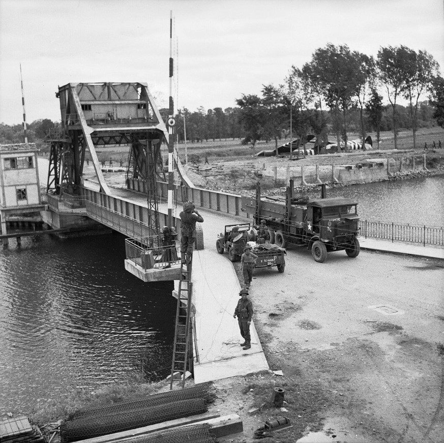 Die nun neu «Pegasus Bridge» benannte Brücke (nach dem Emblem der 6th Airborne Division, welche die Brücke eingenommen hatte) einen Tag nach D-Day. Im Hintergrund sieht man die Horsa-Lastensegler.