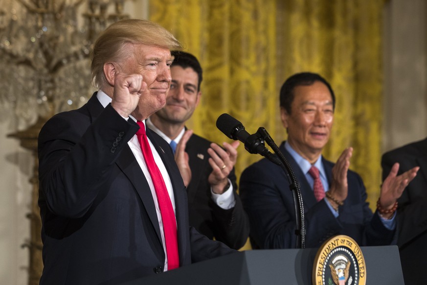 epa06111584 US President Donald J. Trump (L) speaks about the opening of a Foxconn manufacturing plant in Wisconsin while Terry Gou (R), the founder and chairman of Foxconn, looks on in the East Room  ...