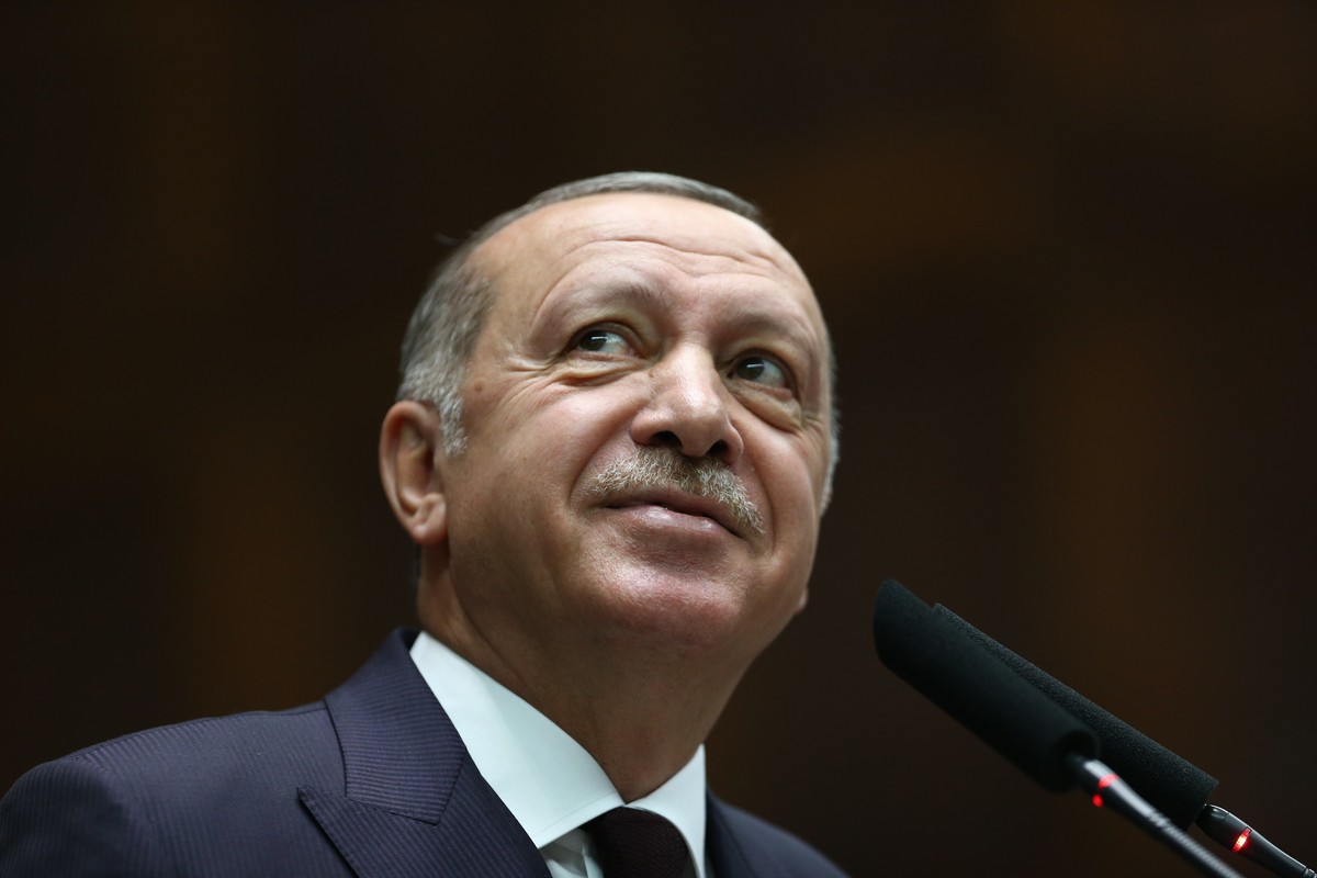 Turkey's President Recep Tayyip Erdogan smiles to supporters as he delivers a speech to MPs of his ruling Justice and Development Party (AKP) at the parliament in Ankara, Turkey, Tuesday, Nov. 6, ...