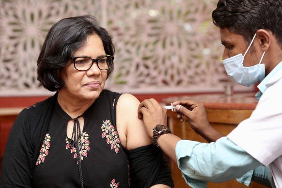 epa09917908 A woman receives a booster shot of a vaccine against COVID-19 during a free vaccination drive in Bangalore, India, 30 April 2022. The government of India and the Karnataka state government ...