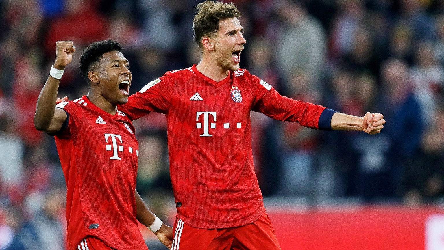 epa07489333 Bayern players David Alaba (L) and Leon Goretzka (R) celebrate after winning the German Bundesliga soccer match between FC Bayern Munich and Borussia Dortmund in Munich, Germany, 06 April  ...