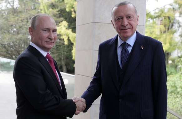 epa09495169 Russian President Vladimir Putin (L) welcomes Turkish President Recep Tayyip Erdogan during their meeting at the Bocharov Ruchei residence in Sochi, Russia, 28 September 2021. According to ...