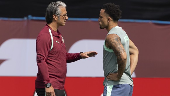 Switzerland's head coach Murat Yakin talks to Noah Okafor during a training session of the Swiss national soccer team at the Killarney Park in Vancouver, Canada, Tuesday, June 23, 2026, during th ...