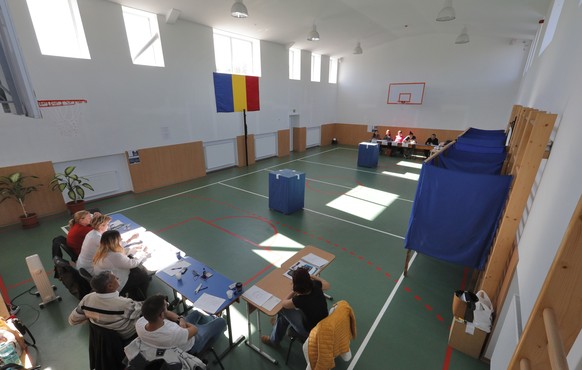 epa07076993 Volunteers are waiting for voters while sitting at their desks inside an empty polling station during the second day of the family re-definition referendum at a polling station in Branesti ...