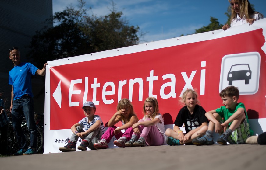 Schüler der Albert-Schweitzer-Grundschule in Hannover (Niedersachsen) stellen am 23.08.2017 mit Vertretern von Polizei und Schule mit einem Banner das Pilotprojekt &quot;Eltern-Taxi&quot; vor. Wenden  ...