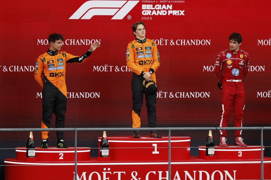 First place, McLaren driver Oscar Piastri of Australia, center, celebrates on the podium with second place McLaren driver Lando Norris of Britain, left, and third place Ferrari driver Charles Leclerc  ...