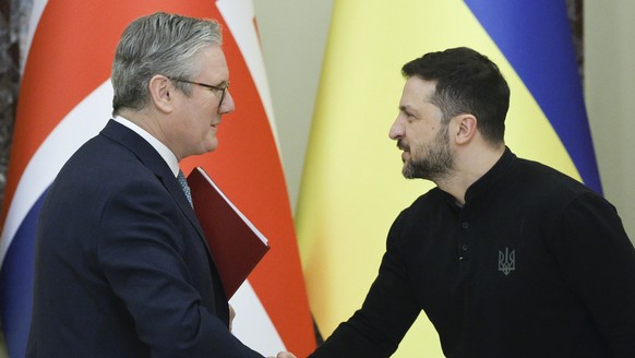 epa11828681 Ukrainian President Volodymyr Zelensky (R) and British Prime Minister Keir Starmer (L) shake hands after a joint press conference following their meeting in Kyiv, Ukraine, 16 January 2025, ...