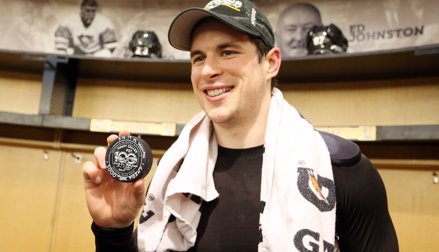 Feb 16, 2017; Pittsburgh, PA, USA; Pittsburgh Penguins center Sidney Crosby (87) poses with the puck used for his 1000th career NHL point against the Winnipeg Jets at the PPG PAINTS Arena. Crosby assi ...