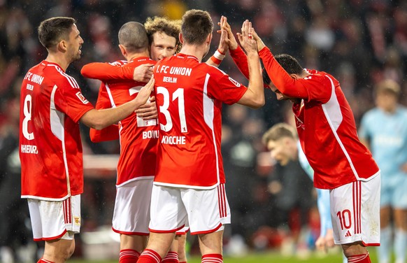 20.12.2023, Berlin: Fu�ball: Bundesliga, 1. FC Union Berlin - 1. FC K�ln, 16. Spieltag, An der Alten F�rsterei. Unions Spieler klatschen sich nach dem Sieg ab. Foto: Andreas Gora/dpa - WICHTIGER HINWE ...