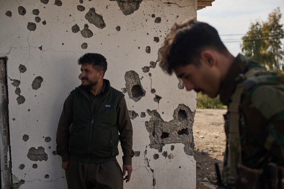 Members of the armed wing of the Kurdish-Iranian opposition group the Organization of Iranian Kurdistan Struggle, known as Khabat, show areas allegedly damaged in a strike by Iranian-backed militias i ...