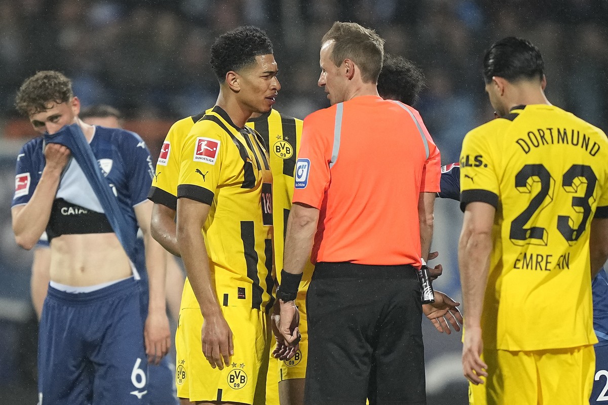 Referee Sascha Stegemann, center, discusses with Dortmund's Jude Bellingham during the German Bundesliga soccer match between VfL Bochum and Borussia Dortmund in Bochum, Germany, Friday April 28, ...