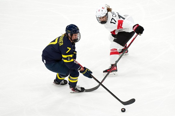 Sweden's Mira Jungaker (7) moves the puck against Switzerland's Lara Christen (17) during the third period of the women's ice hockey bronze medal game at the 2026 Winter Olympics, in Mi ...