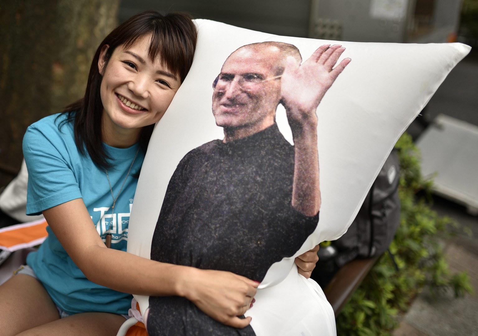 epa05541644 Apple enthusiast Ayano Tominaga poses with a pillow bearing an image of Apple co-founder Steve Jobs after she bought the new iPhone 7 at the Apple Store of Omotesando shopping district in  ...