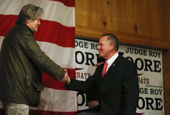 Steve Bannon, left, introduces U.S. senatorial candidate Roy Moore, right, during a campaign rally, Tuesday, Dec. 5, 2017, in Fairhope, Ala. (AP Photo/Brynn Anderson)