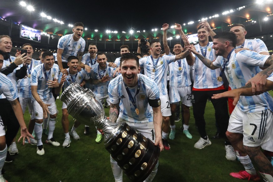 Argentina&#039;s Lionel Messi celebrates with the trophy after beating Brazil 1-0 in the Copa America final soccer match at the Maracana stadium in Rio de Janeiro, Brazil, Saturday, July 10, 2021. (AP ...