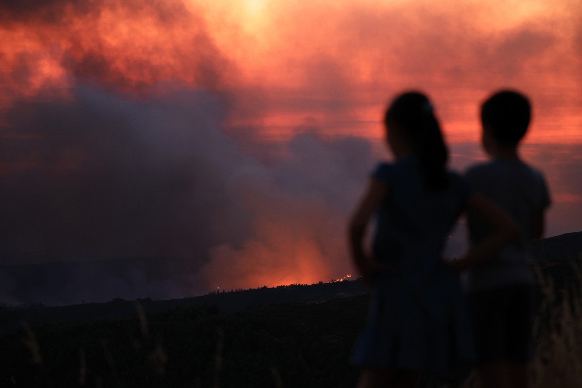 epa12271461 Children watch the fire in Arouca, Portugal, 29 July 2025. The fire that has been raging for more than 24 hours in Arouca, in the district of Aveiro, has three active fronts and has alread ...