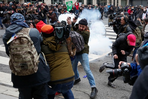 Activists and journalists get hit by a stun grenade during a protest against U.S. President Donald Trump on the sidelines of the inauguration in Washington, D.C. January 20, 2017. REUTERS/Adrees Latif