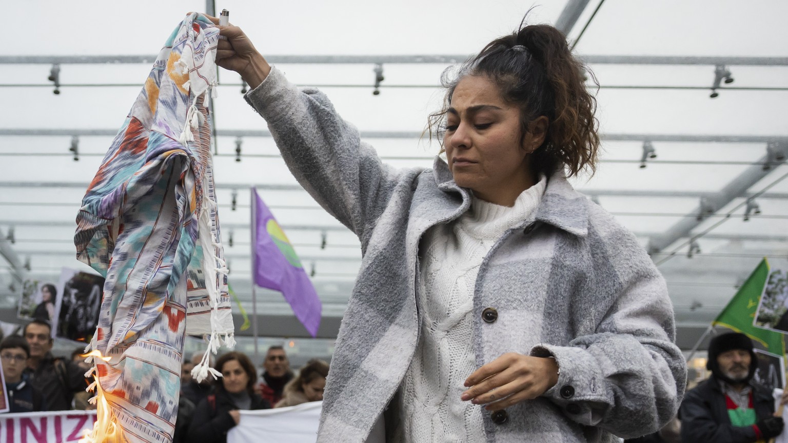 An Iranian woman burns her headscarf during a rally against the death of Iranian Mahsa Amini in Bern, Switzerland, Tuesday, September 27, 2022. They were protesting against the death of Iranian Mahsa  ...