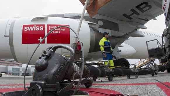 ARCHIV - ZUR MELDUNG DASS DIE SWISS FLUGGESELLSCHAFT DANK TIEFEM OELPREIS UND SPARMASSNAHMEN MEHR GEWINN MACHT STELLEN WIR IHNEN FOLGENDES ARCHIVBILD ZUR VERFUEGUNG. - A worker fills kerosene into an  ...