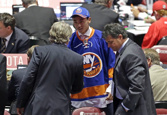 Andong Song, center, of China, shakes hand withe team executives after being chosen 172nd overall by the New York Islanders during the sixth round of the NHL hockey draft, Saturday, June 27, 2015, in  ...