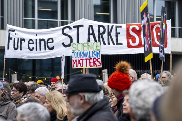 Einige hundert Menschen demonstrieren mit Plakaten fuer einen starken Wissenschaftsjournalismus bei der SRG, in Basel, am Samstag, 22. Februar 2025. Eine Petition gegen die Abschaffung des Wissenschaf ...