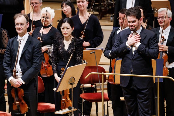epa12381135 Israeli conductor Lahav Shani (R) reacts to applause during a performance at the Konzerthaus venue in Berlin, Germany, 15 September 2025. Shani was set to conduct the Munich Philharmonic O ...