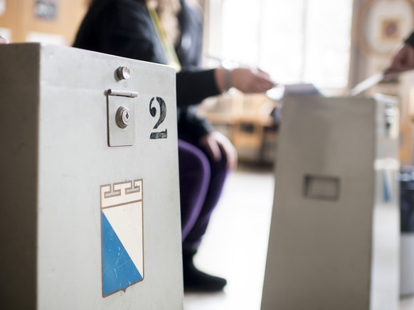 Einwohner werfen im Schulhaus Aemtler im Kreis 3 ihre Abstimmungsunterlagen in die Urne, aufgenommen am Sonntag, 4. Maerz 2018 in Zuerich. (KEYSTONE/Ennio Leanza)