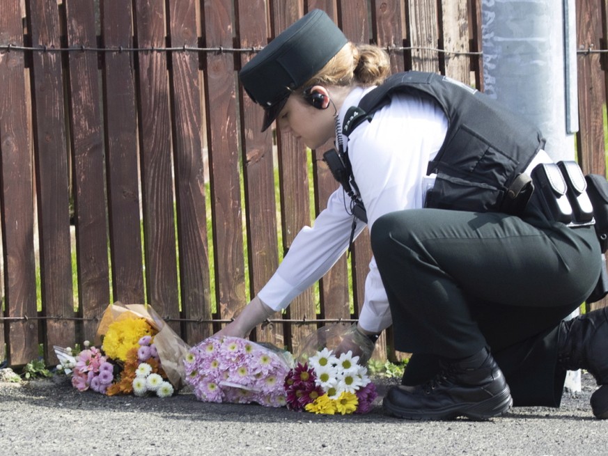 Eine Polizistin legt Blumen nieder, wo die Journalistin Lyra McKee von einer Kugel getroffen wurde und starb. Die Ordnungshüter vermuten, dass katholische Extremisten hinter der Tat stehen.