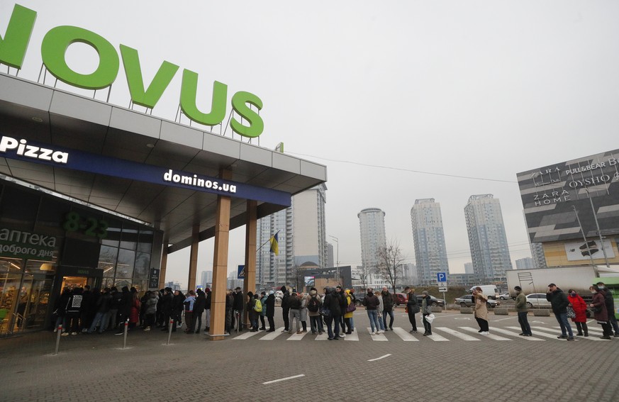 epa09780300 People stand in line outside a grocery store in Kiev (Kyiv), Ukraine, 24 February 2022. Russian troops entered Ukraine while the country's President Volodymyr Zelensky addressed the n ...