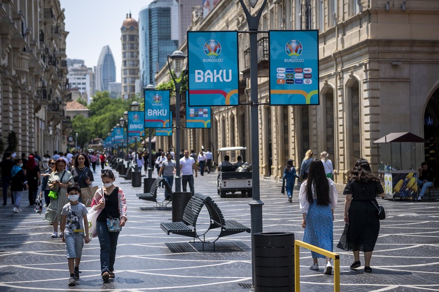 People walk past signs promoting the UEFA EURO 2020 soccer tournament, in Baku, Azerbaijan, Tuesday, June 8, 2021. The UEFA EURO 2020 soccer tournament will be held from 11 June to 11 July 2021. (KEYS ...