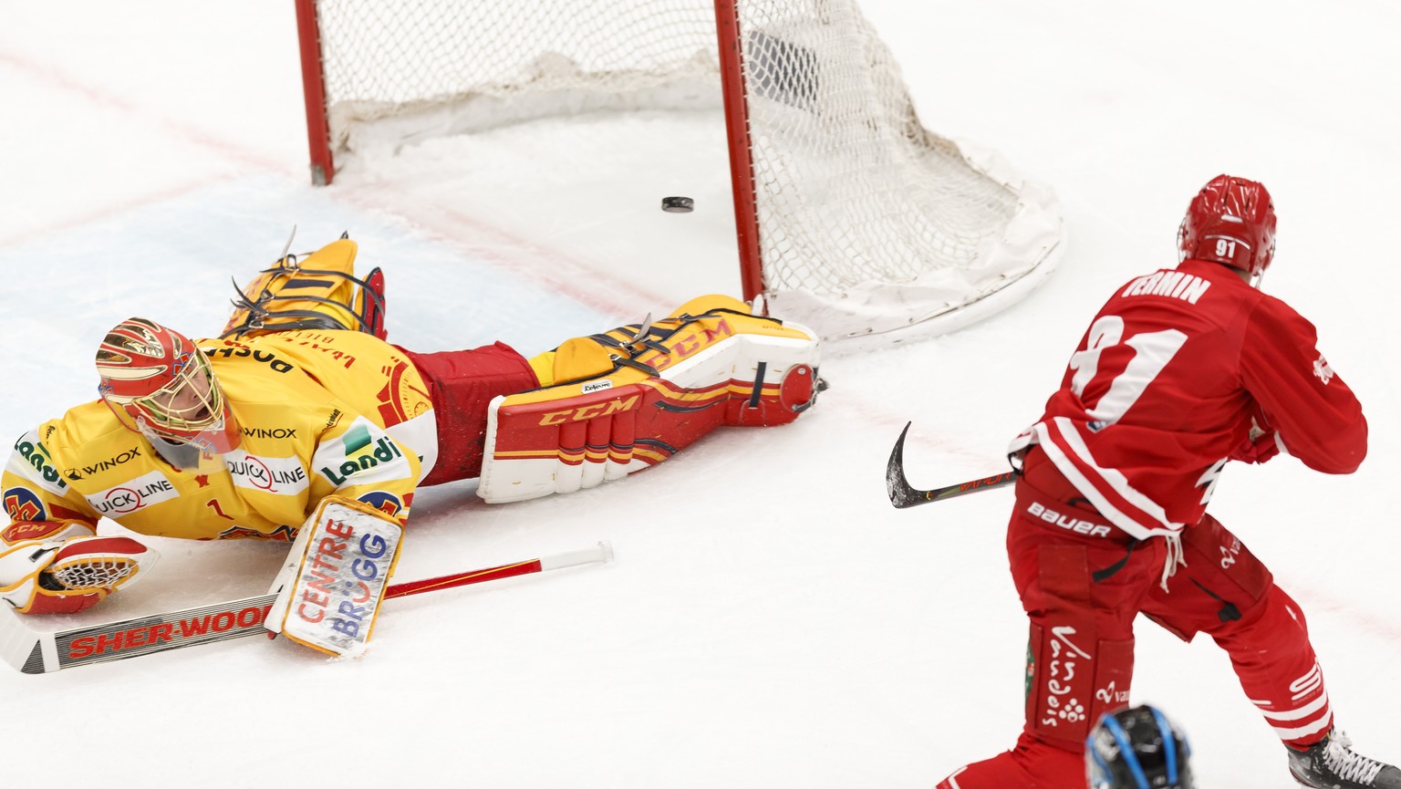 Le gardien biennois Jonas Hiller, gauche, encaisse le premier but face a l&#039;attaquant lausannois Joel Vermin, droite, lors de la rencontre du championnat suisse de hockey sur glace de National Lea ...