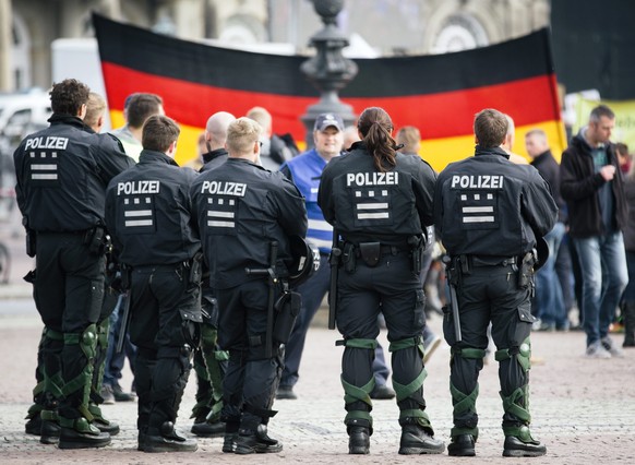 epa05587747 Policemen watch supporters of the PEGIDA (Patriotic Europeans Against the Islamisation of the Occident) movement gathering on the Theatre Square in Dresden, Germany, 16 October 2016. The f ...