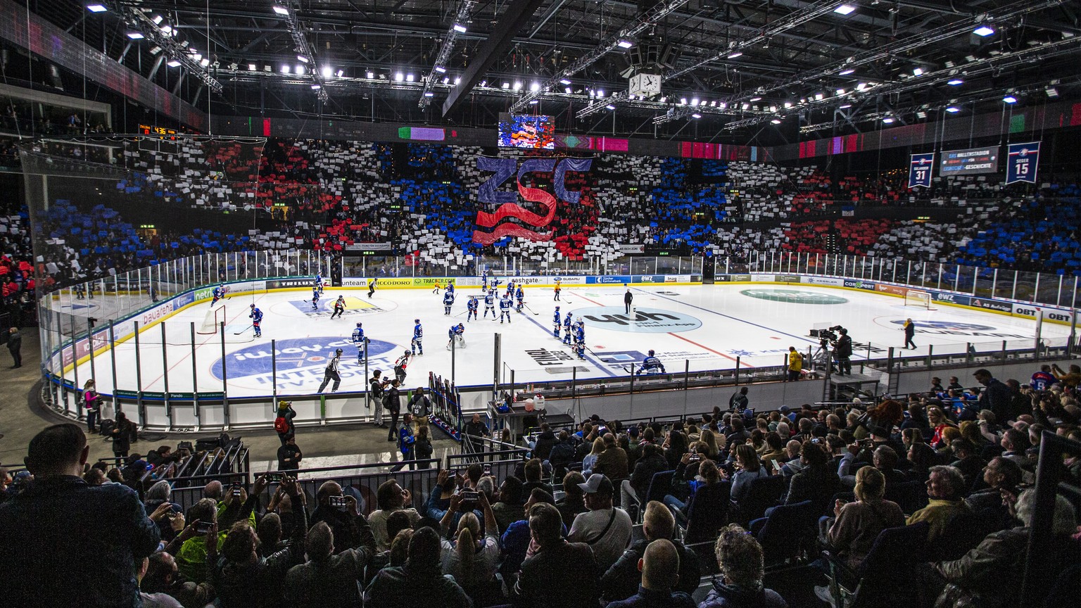 Die Zuschauer heissen die ZSC Lions mit farbigen Papieren willkommen im vierten Eishockey Playoff-Finalspiel der National League A zwischen den ZSC Lions und dem EV Zug am Montag, 25. April 2022, im H ...