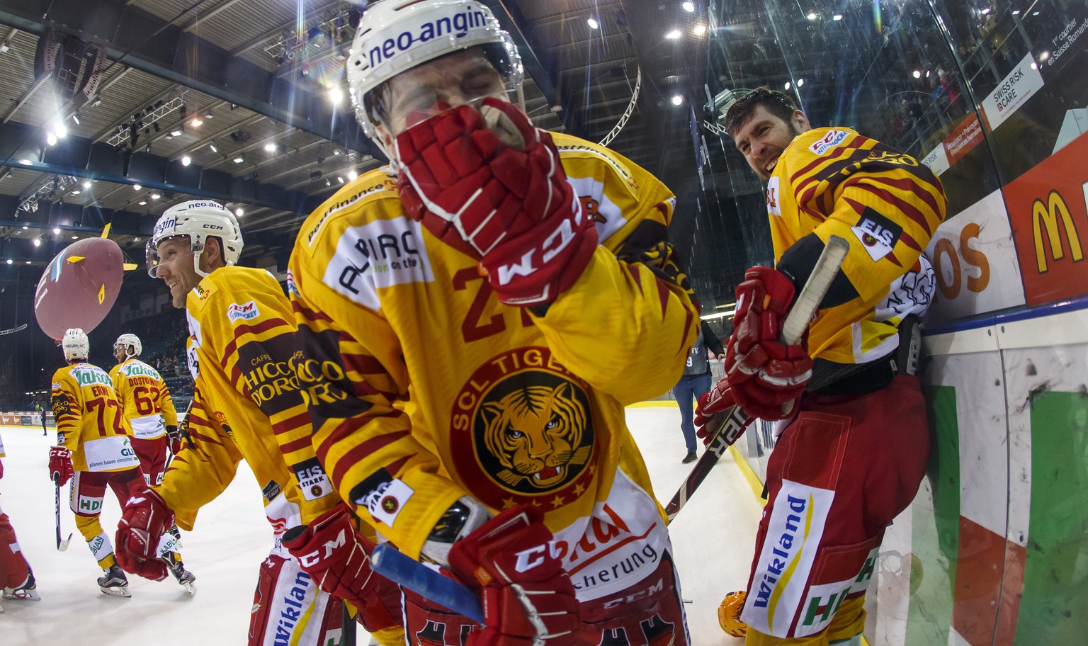 Tiger&#039;s players center Aaron Gagnon, of Canada, left, defender Anthony Huguenin, center, and forward Christopher DiDomenico, of Canada, right, celebrate their victory after beating Geneve-Servett ...