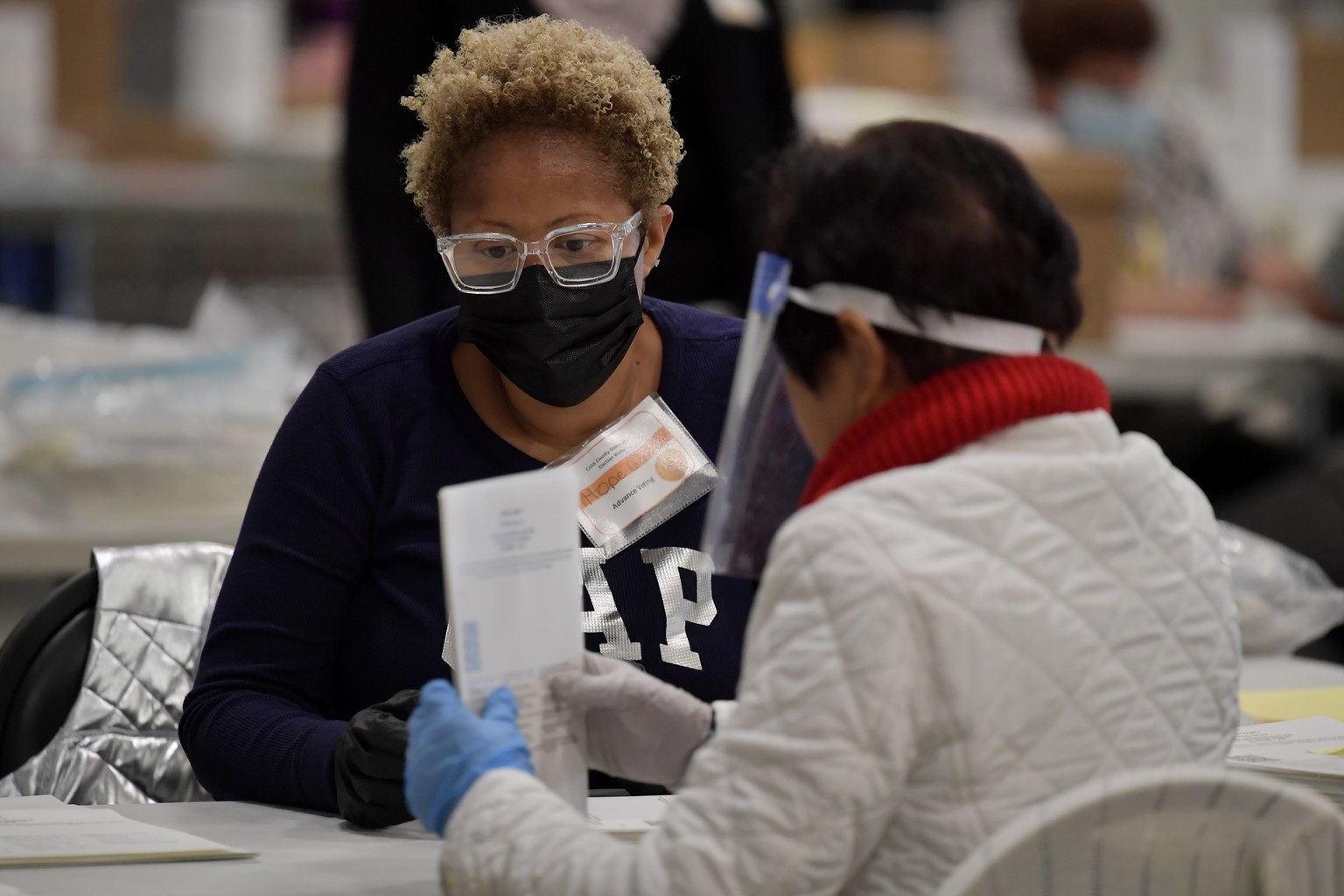 Cobb County Election officials handle ballots during an audit, Monday, Nov. 16, 2020, in Marietta, Ga. (AP Photo/Mike Stewart)