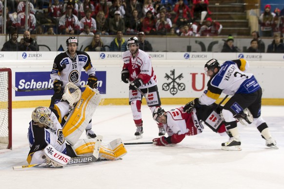 Lugano&#039;s goalkeeper Elvis Merzlikins, Lorenz Kienzle and Julien Vauclair, from left, fights for the puck with Team Canada&#039;s Tom Pyatt and Chris Didomenico, from left, during the final game b ...