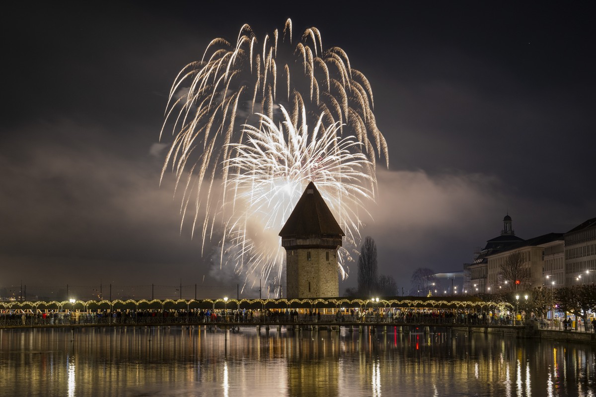 The New year fireworks explode over the famous Chapel Bridge and Old Town in Lucerne, Switzerland, on Wednesday, January 1, 2025. (KEYSTONE/Urs Flueeler)..Mit einem Feuerwerk ueber dem Luzerner Seebec ...