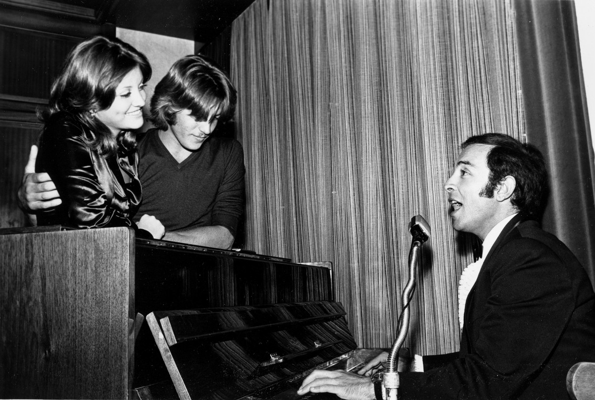 Singer and pianist Gene Maalouf, right, performs for Lebanon's Miss Universe of 1971, Georgina Rizk, and her boyfriend, Philip Duc, in Beirut, August 13, 1971. (AP Photo/Harry Koundakjian)