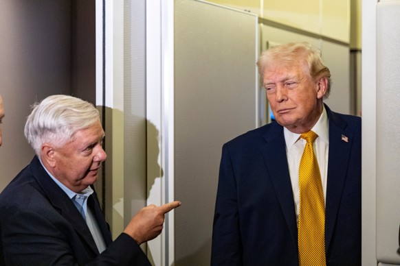 FILE - Sen. Lindsey Graham, R-S.C., left, gestures as President Donald Trump speaks with reporters while in flight on Air Force One, Jan. 4, 2026, as they were returning to Joint Base Andrews, Md. (AP ...