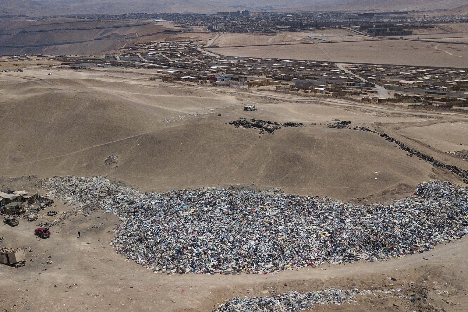 A large pile of second-hand clothing covers the sand near La Mula neighborhood in Alto Hospicio, Chile, Monday, Dec. 13, 2021. Chile is a big importer of second hand clothing, and unsold clothing gets ...