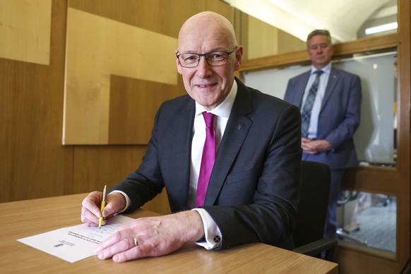 New Scottish National Party (SNP) leader John Swinney signs his letter of nomination to become First Minister at the Scottish Parliament in Edinburgh, Tuesday, May 7, 2024. (Jeff J Mitchell/PA via AP)